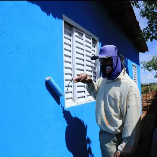 Trabalhador pintando casa