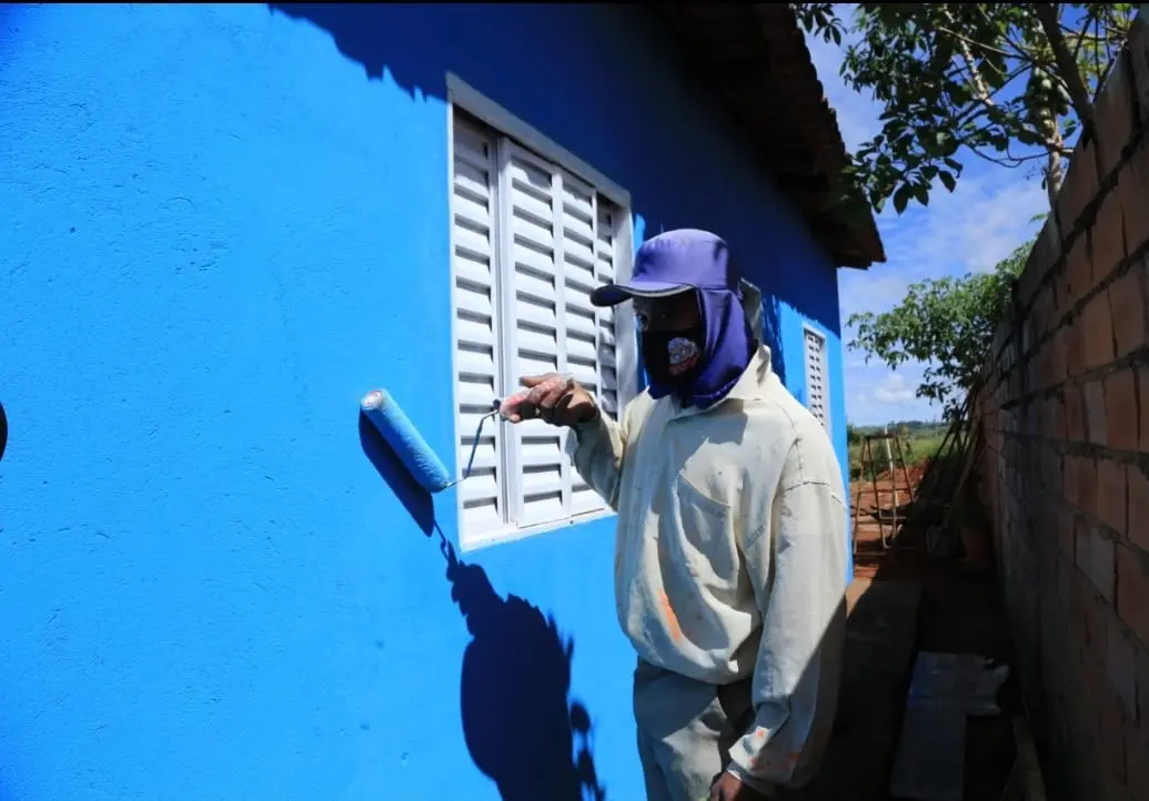 Trabalhador pintando casa