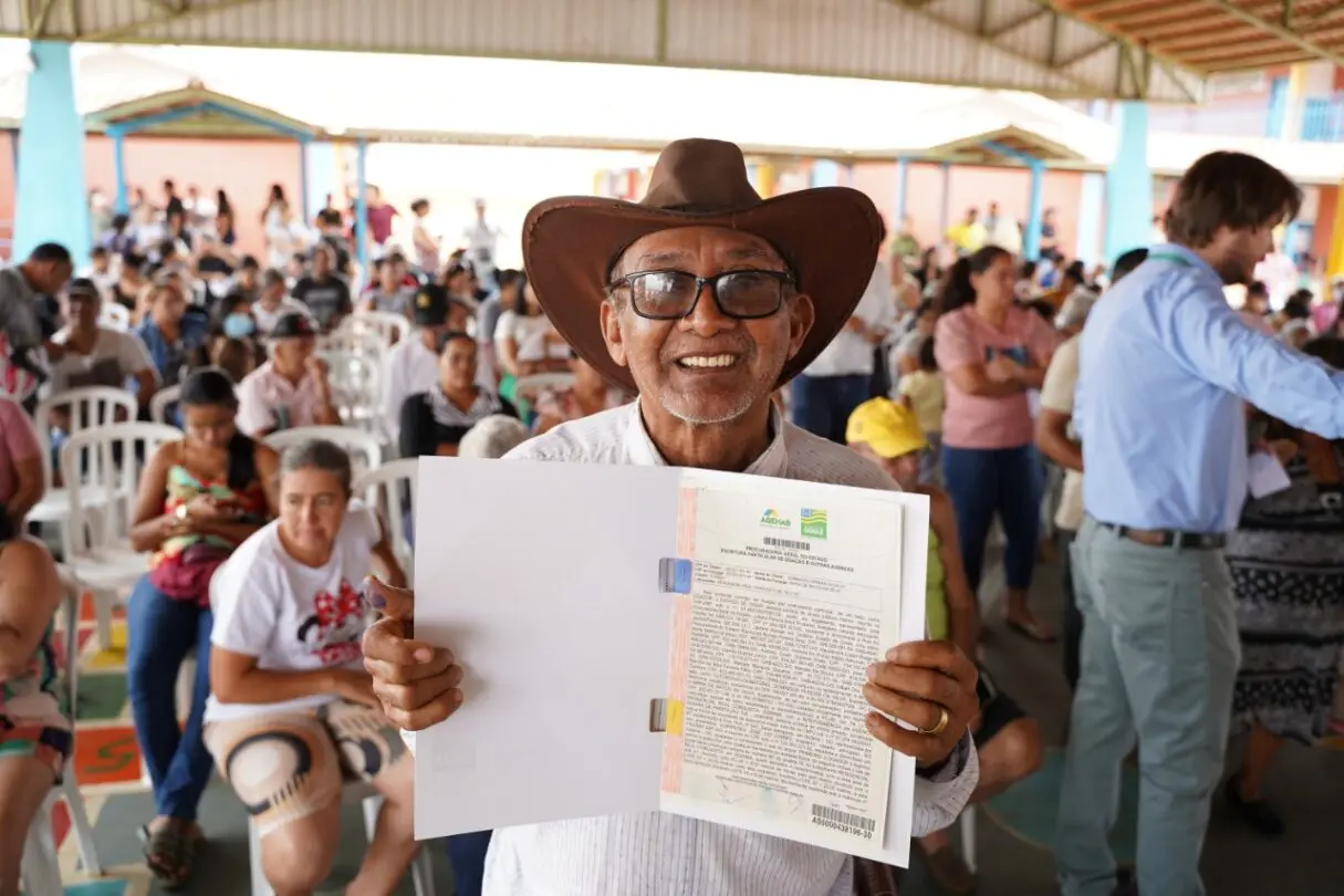 Investimentos- Um senhor de aproximadamente 65 anos mostrando o documento de regularização fundiária de seu imóvel