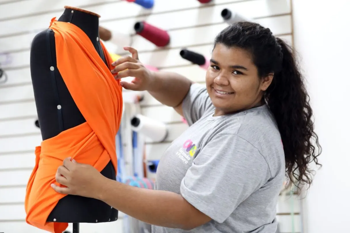 Uma jovem colando vestuário em um manequim