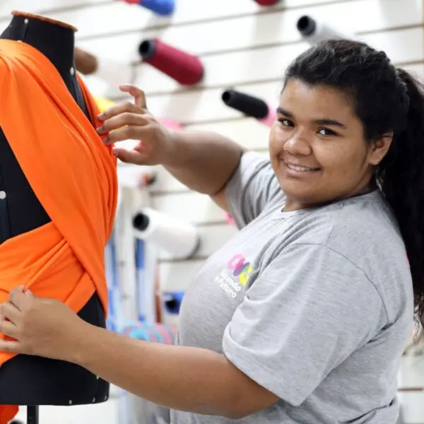 Uma jovem colando vestuário em um manequim