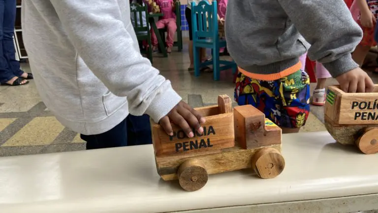 Criança brincando com brinquedo feitos por detentos do Complexo Prisional de Aparecida