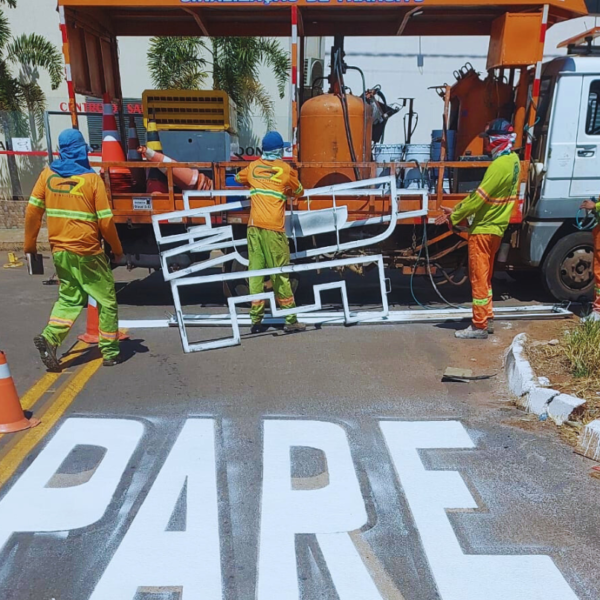 Equipes do Detran pintando faixa em rua pelo programa Sinaliza Goiás