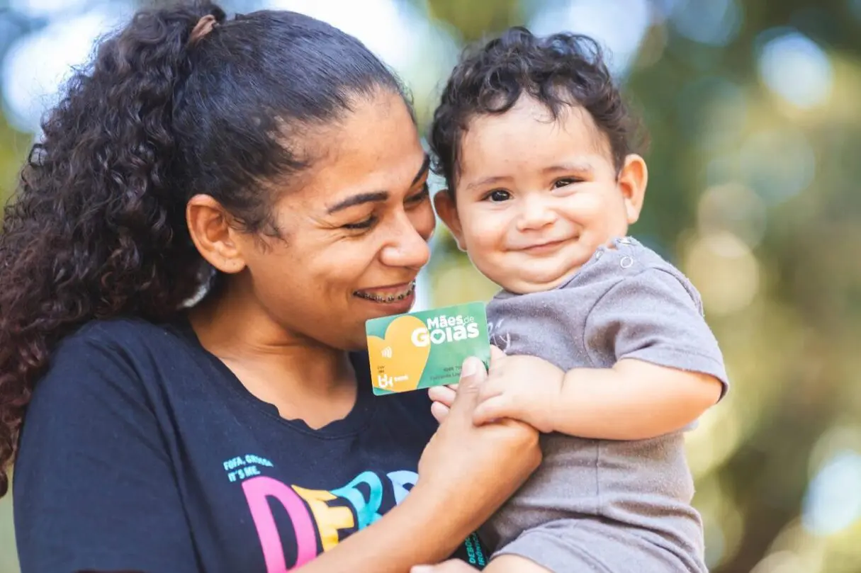 Mãe e filho com cartão do Mães de Goiás