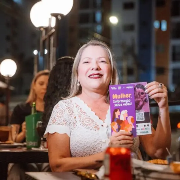 Mulher segurando foldes do Protocolo Todos por Elas