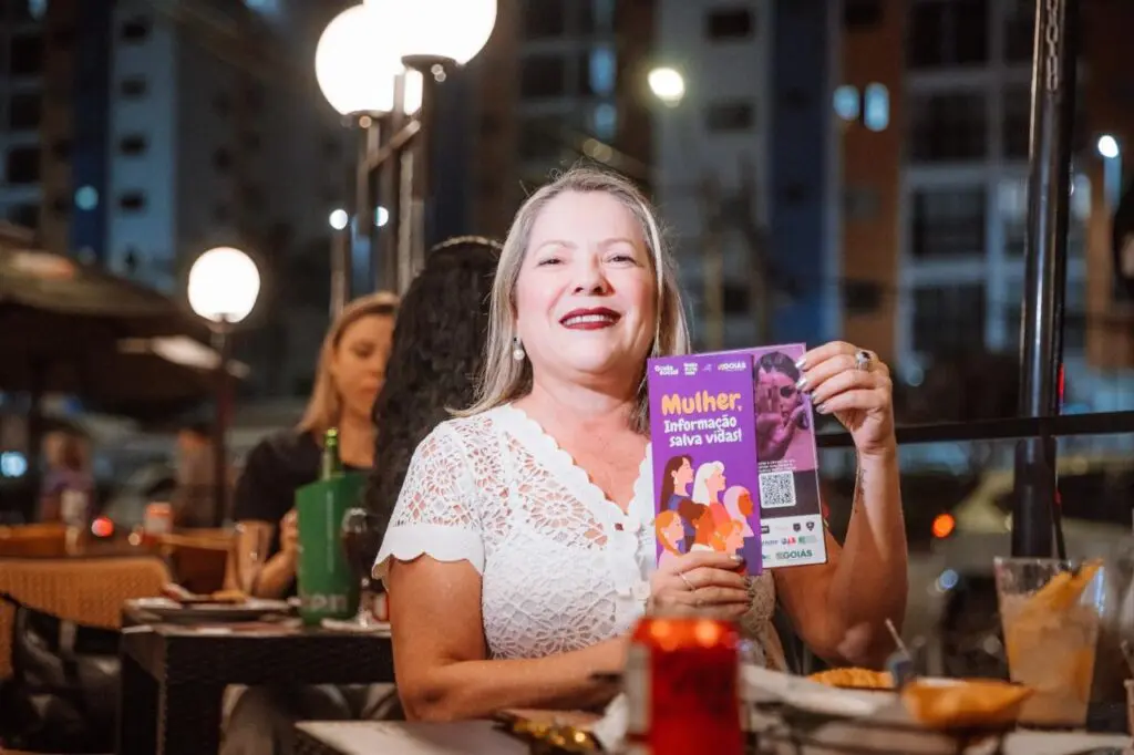 Mulher segurando foldes do Protocolo Todos por Elas