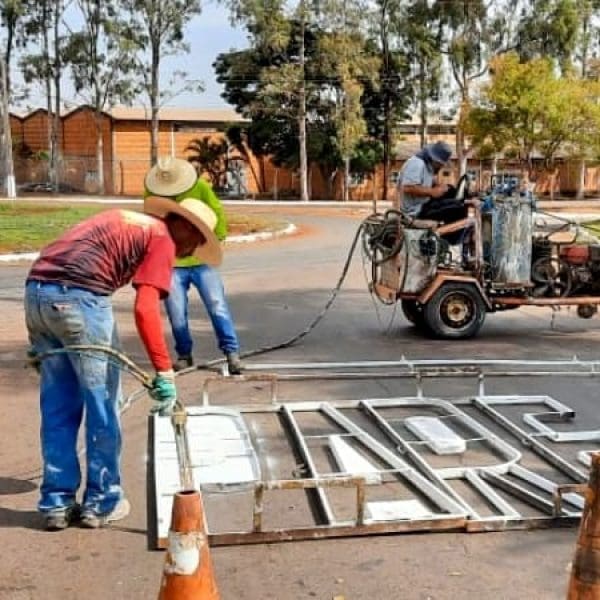 trabalhadores pintando sinalização