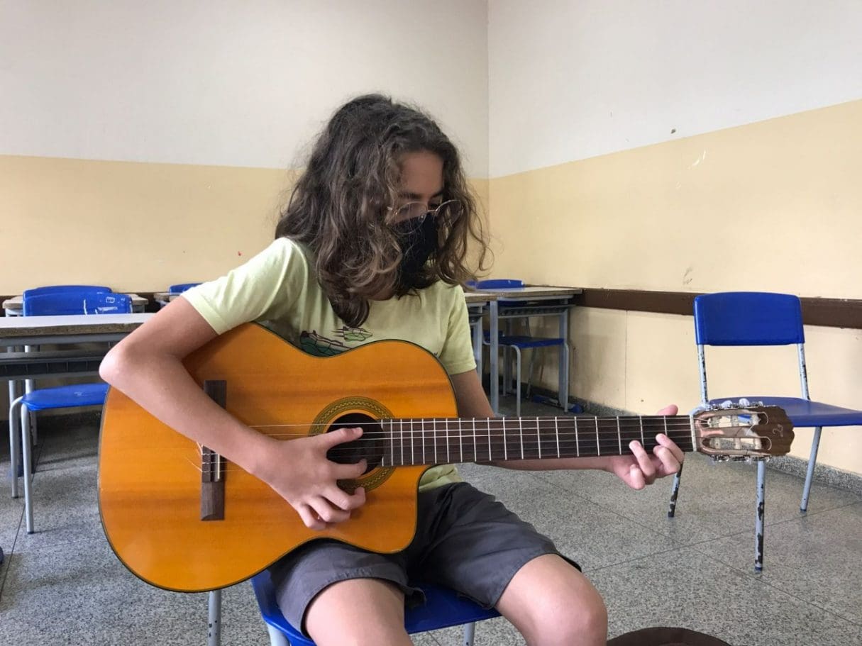 aluno tocando violão