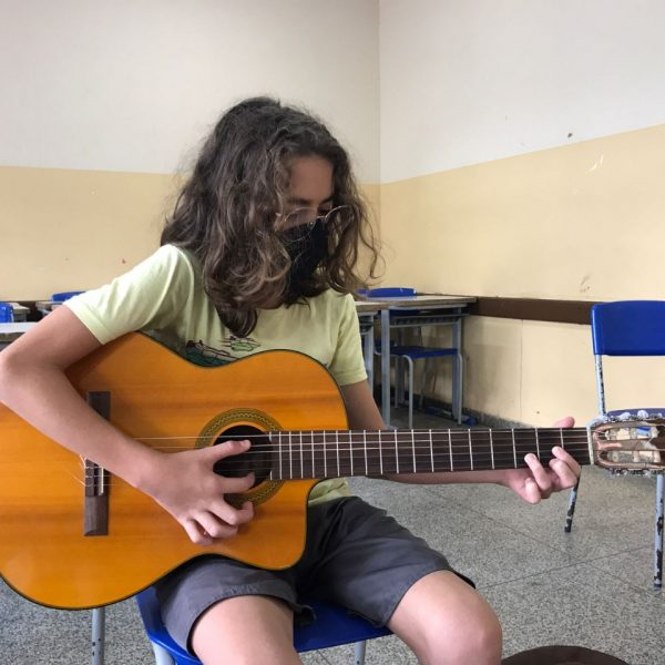 aluno tocando violão
