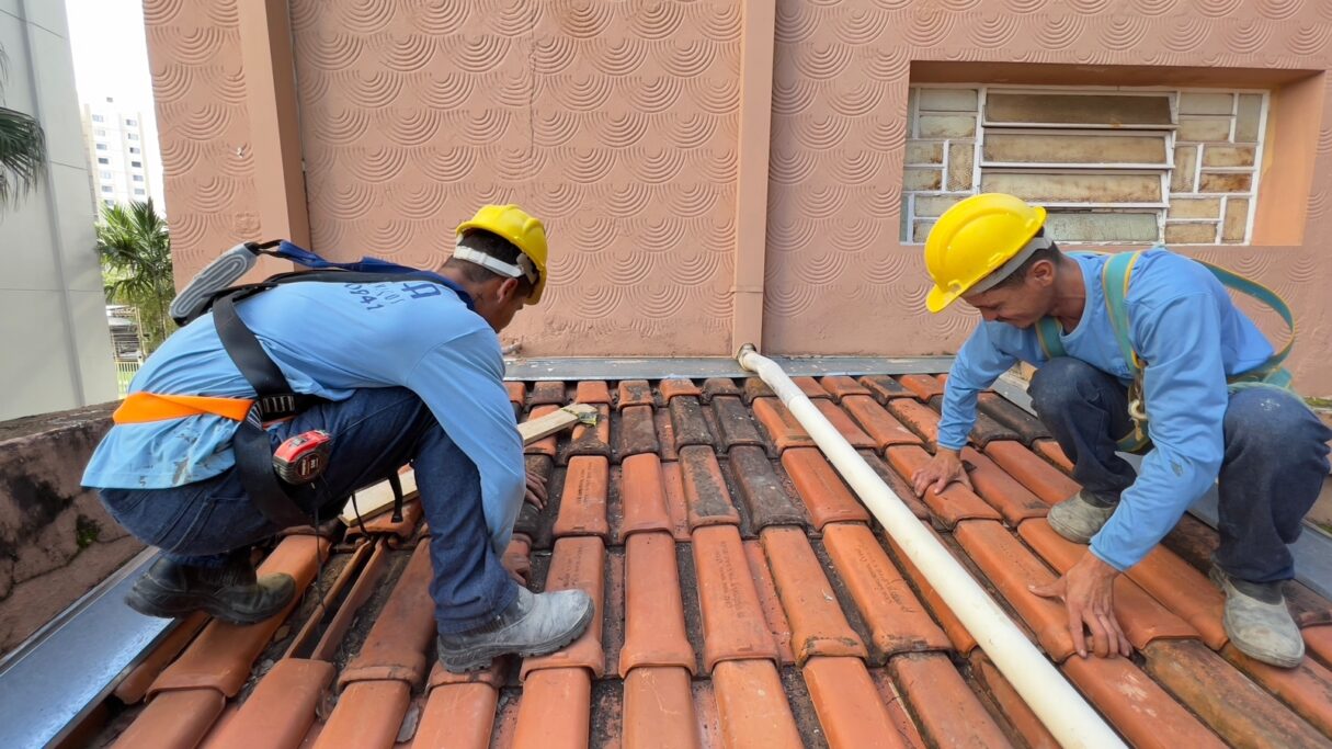 Dois trabalhadores fazendo reparos no telhado do museu Pedro Ludovico