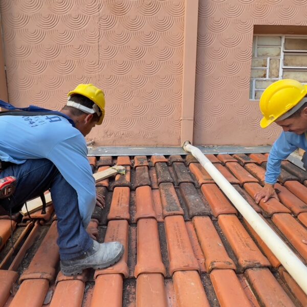 Dois trabalhadores fazendo reparos no telhado do museu Pedro Ludovico