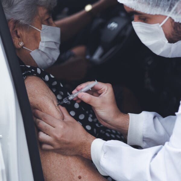 Pessoa idosa recebendo vacina bivalente contra covid-19