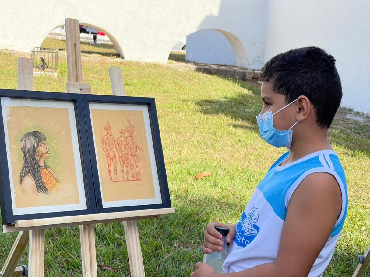 Menino olhando obra de arte_Mostra na Vila Cultural Cora Coralina