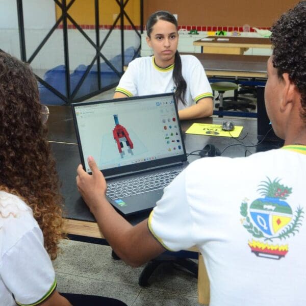 Alunos da Escola do Futuro em frente a um notebook