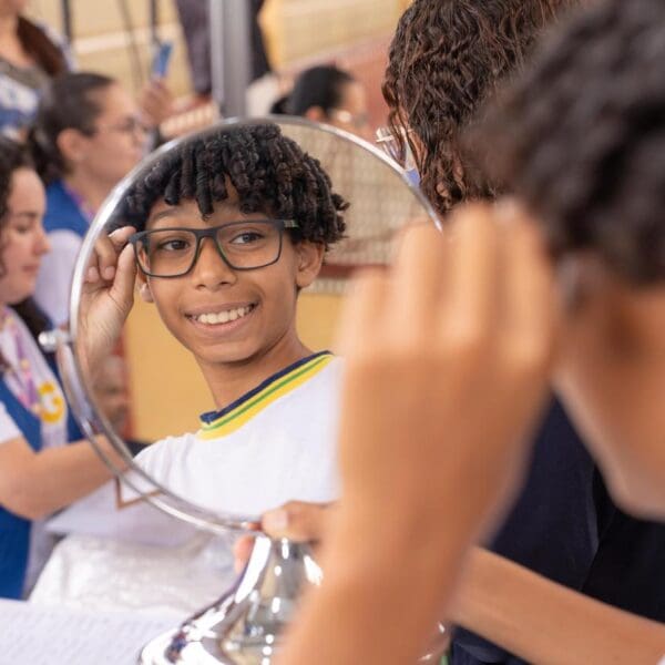 Aluno experimenta óculos doad opelo Olhas para Todos