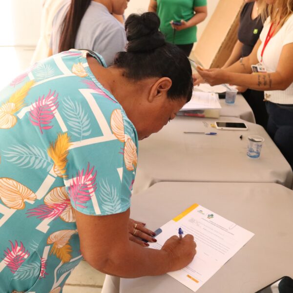 mulher assina escritura do programa casas a custo zero_Agehab