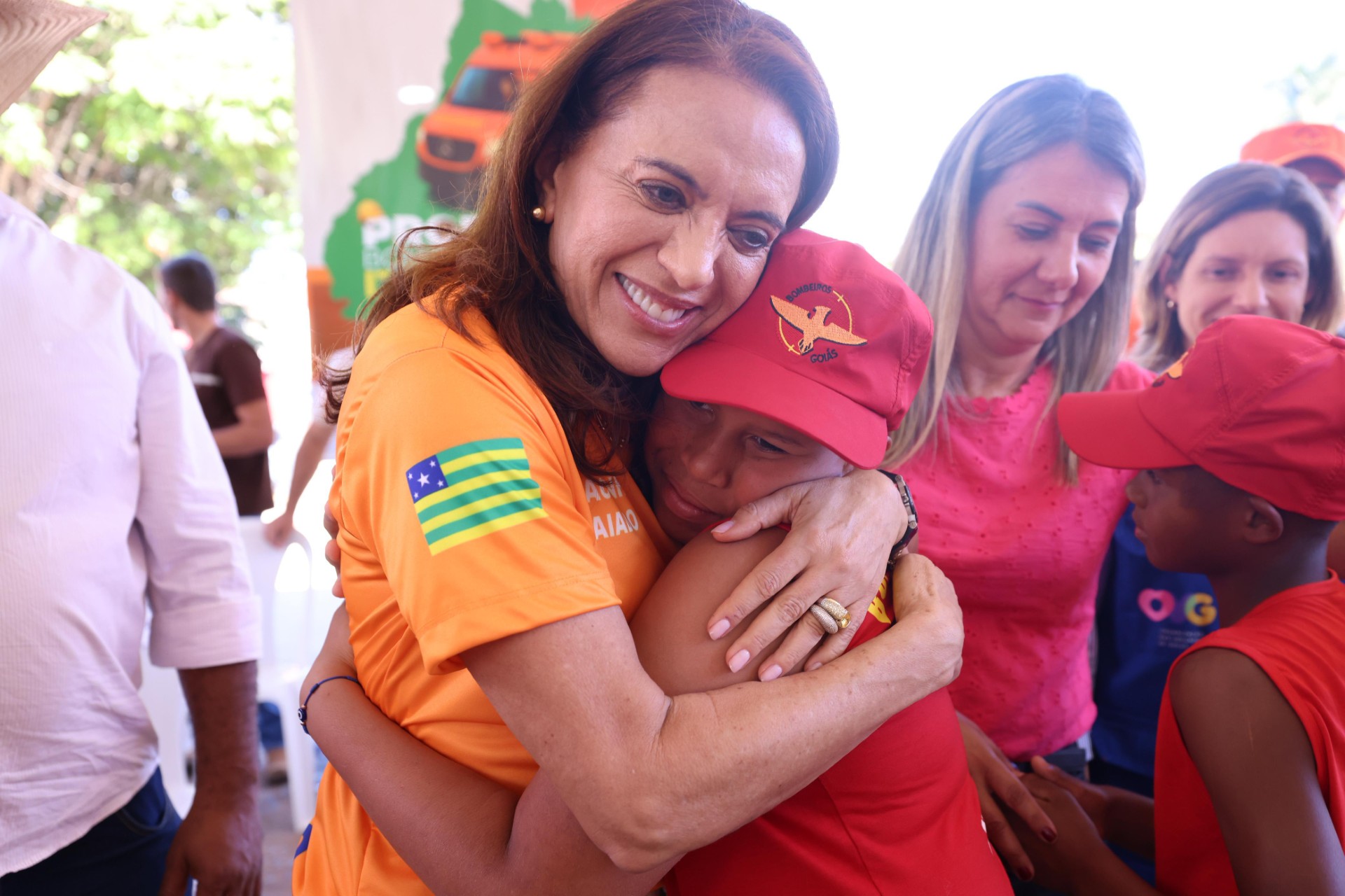 Gracinha abraçando criança, bombeiro mirim, durante formatura de 46 alunos no Programa Bombeiro Mirim, que este ano ganhou ação itinerante