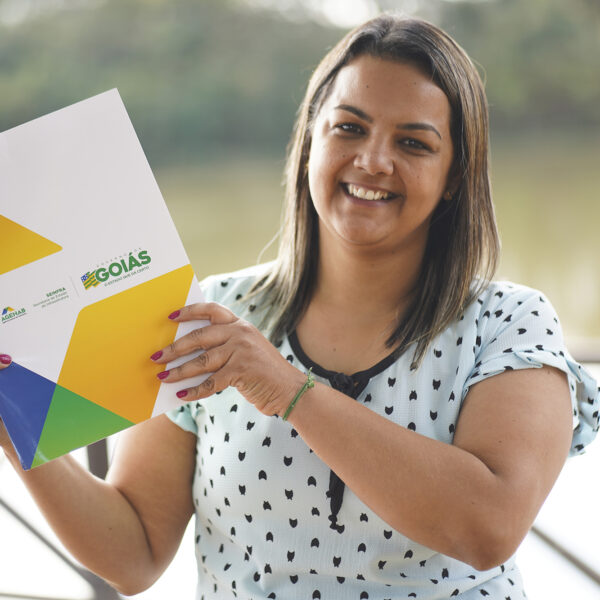 mulher com escritura do imóvel nas mãos