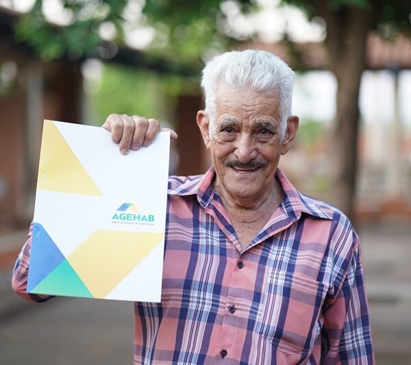 Morador segurando escritura entregue pela Agehab