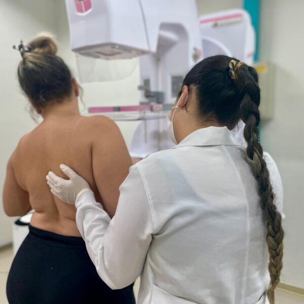 Campanha Portas Abertas do Governo de Goiás faz mais de mil mamografias em 5 dias - Mulher, auxiliada por profissional de saúde, durante realização de mamografia