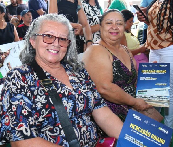 Pessoas segurando a revista do Mercadão Goiano