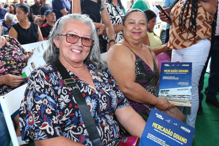 Pessoas segurando a revista do Mercadão Goiano