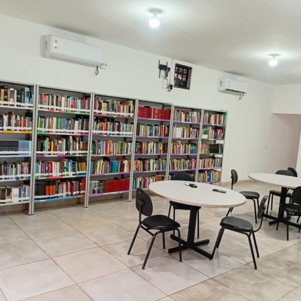 Secult doa de mais de mil livros para biblioteca municipal de Baliza - Espaço interno da biblioteca com estante de livros, mesas redondas brancas e cadeiras pretas