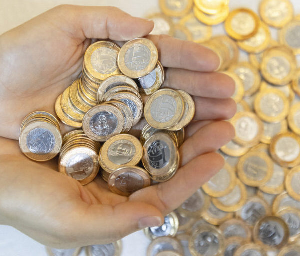 Mais de 80 ganhadores do sorteio de dezembro da Nota Goiana ainda não resgataram prêmios - mãos, de uma pessoa branca, em forma de concha segurando moedas de um real