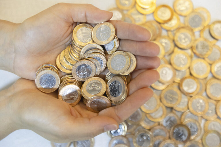 Mais de 80 ganhadores do sorteio de dezembro da Nota Goiana ainda não resgataram prêmios - mãos, de uma pessoa branca, em forma de concha segurando moedas de um real